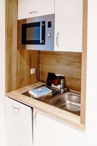 a kitchen with a sink and a microwave at Haus am See Luxury HS 224 B in Hahnenklee-Bockswiese