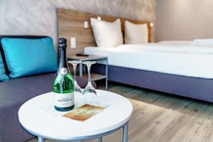um quarto com uma garrafa de vinho e copos numa mesa em Haus am See Luxury HS 224 B em Hahnenklee-Bockswiese