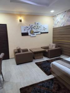 a living room with two couches and a table at Fawzy Hotel in Ibadan