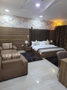 a bedroom with a large bed and a couch and a couch at Fawzy Hotel in Ibadan