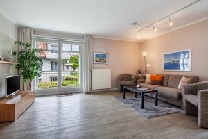 a living room with a couch and a tv at Seebach Wohnung 18 in Boltenhagen