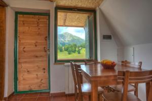 a dining room with a table and a window at Apartmani i Restoran Sljeme in Žabljak