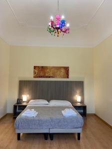 a bedroom with a bed and a chandelier at 55 Aira Hotel in Palermo