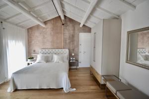ein Schlafzimmer mit einem weißen Bett und einem großen Fenster in der Unterkunft Rubiera Relais B&B in Rubiera