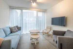 een woonkamer met een bank, een tafel en een tv bij Singel 9a in Domburg