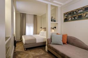 um quarto de hotel com uma cama e um sofá em Hotel Smeraldo em Roma