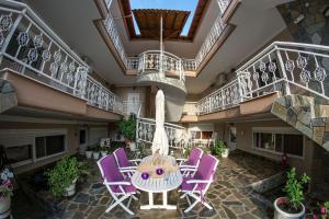 a patio with purple chairs and a table in a building at Sky Hotel in Sarti