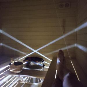 a person laying on a table in a room with a stove at Domek pod chałpom sauna & bania in Gliczarów