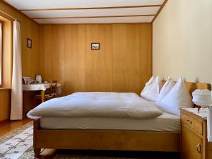 um quarto com uma cama grande e uma parede de madeira em Pensione Capelli em Prada