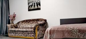 ドニプロにあるКвартира на проспекте Поля 127のベッドルーム1室(ソファ、ベッド横の椅子付)