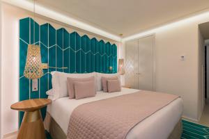 a bedroom with a large bed and a green wall at Room Mate Macarena, Madrid Gran Vía in Madrid