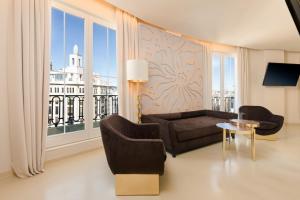 a living room with a couch and a large window at Room Mate Macarena, Madrid Gran Vía in Madrid +54 photos