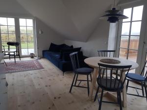 ein Wohnzimmer mit einem blauen Sofa und einem Tisch in der Unterkunft Fiskerhuset in Agger