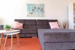 a living room with a gray couch and a table at Estrela do Oceano in Portimão