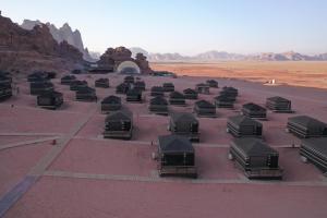 a group of tents in a desert with mountains at Sun City Camp in Wadi Rum