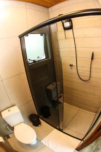 a small bathroom with a toilet and a shower at Bossa Beach House in Ilha do Mel