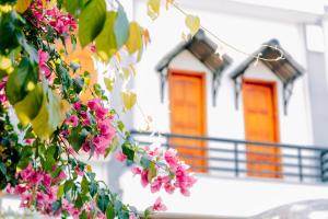 dom z pomarańczowymi drzwiami i różowymi kwiatami w obiekcie Window 2 Hotel w mieście Kon Tum