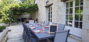 uma mesa azul e cadeiras num pátio em La Magnanerie em Savigny-en-véron