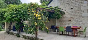 pérgola con mesa, sillas y flores en La Magnanerie, en Savigny-en-véron