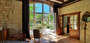 Una habitación con una gran puerta de cristal que da a un patio. en La Magnanerie, en Savigny-en-véron 2 fotos más
