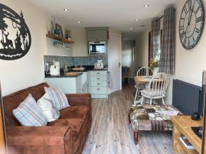 a living room with a couch and a kitchen at Ye Old Tack Room in Stafford