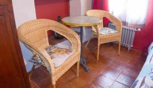 アレーナス・デ・サン・ペドロにあるPosada El Canchalの籐の椅子2脚とテーブル1台