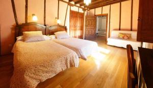 a bedroom with two beds and a wooden floor at Posada El Canchal in Arenas de San Pedro