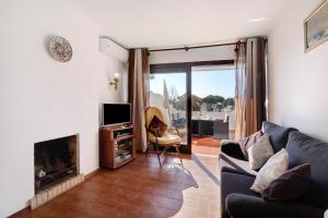 a living room with a couch and a fireplace at T2 Balaia in Albufeira