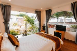 a bedroom with a bed and a large window at Window Homestay in Kon Tum +117 photos
