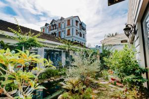 a garden in front of a building with plants at Window Homestay in Kon Tum