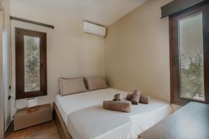 un dormitorio con una cama con dos animales de peluche en AIORA villas, en Ammoulianí