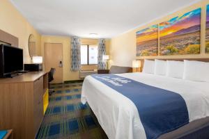 a hotel room with a large bed and a flat screen tv at Days Inn by Wyndham Alamogordo in Alamogordo