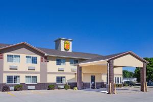 a hotel with a building with a clock on it at Super 8 by Wyndham Emmetsburg in Emmetsburg
