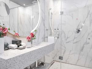 a white bathroom with a shower and a sink at Sofitel Roma Villa Borghese in Rome