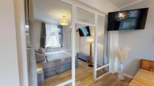 a room with a living room with a large mirror at Lieblingsapartment No.4 in Top-Citylage mit 2 Schlafzimmern in Rostock