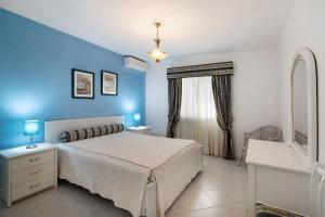 a bedroom with a bed and a blue wall at Apartamento Nautilus in Armação de Pêra