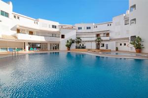 a swimming pool in front of a building at Apartamento Nautilus in Armação de Pêra