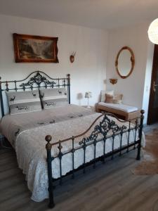 a bedroom with a large bed and a mirror at B&B Neuses am Brand in Sonnefeld