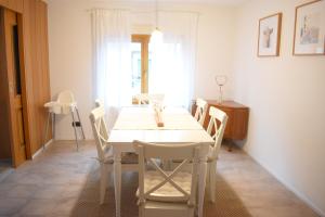 une salle à manger avec une table et des chaises blanches dans l'établissement OB Ferienwohnung Sensbachtal, à Untersensbach