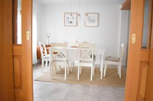 une salle à manger avec une table et des chaises blanches dans l'établissement OB Ferienwohnung Sensbachtal, à Untersensbach