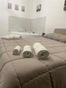 two rolled towels on a bed in a room at Rosa Dei Venti Apartment in Catania