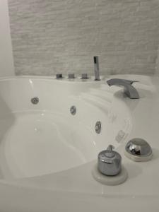 a white bath tub with a faucet in a bathroom at Rosa Dei Venti Apartment in Catania