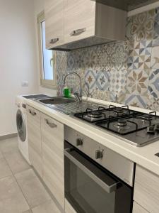 a kitchen with a stove and a sink at Rosa Dei Venti Apartment in Catania