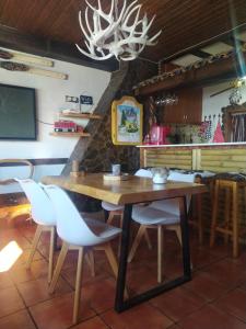 a dining room with a wooden table and white chairs at Apartamento De Lujo En Sierra Nevada in Sierra Nevada