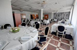 a banquet room with white tables and chairs with white tablecloths at Hotel Vila-real Azul in Villareal