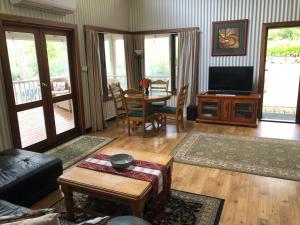 デンマークにあるLakeside Garden Chaletのテーブルとテレビのあるリビングルーム