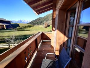 a balcony with two chairs and a window and mountains at Appartements Berger Kitzbühel in Kitzbühel