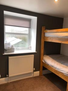 1 Schlafzimmer mit 2 Etagenbetten und einem Fenster in der Unterkunft The Prince of Wales Bed and Breakfast in Princetown