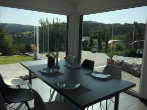 a dining room table with chairs and a large window at Panoramablick in Adenau