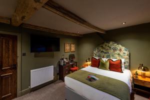 a bedroom with a large bed and a television at The Plough in Wigglesworth